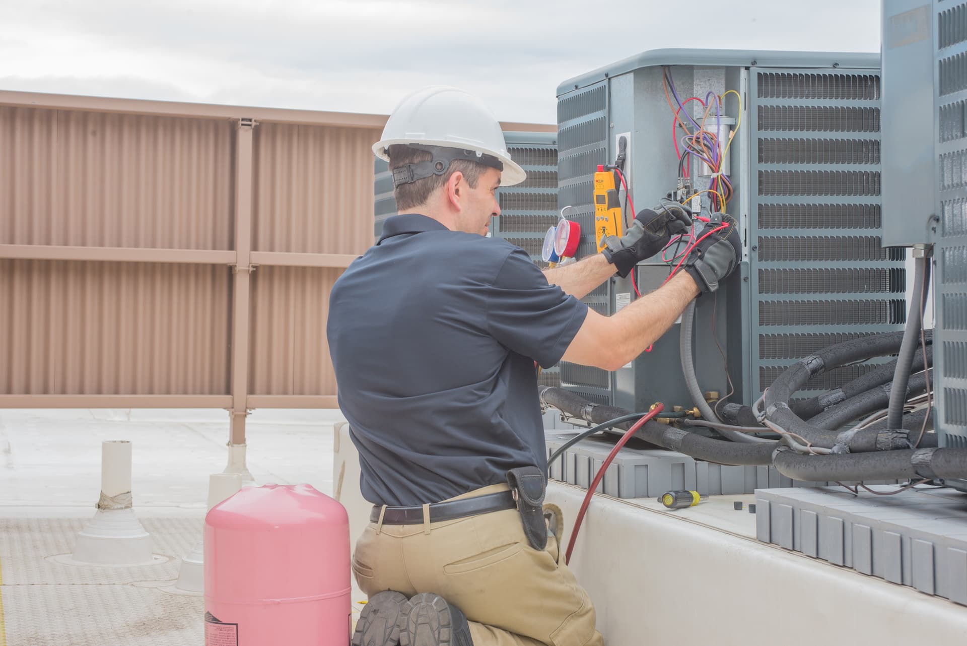 Commercial HVAC technicians working on rooftop unit installation